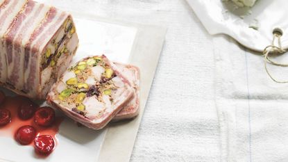 Chicken and pistachio terrine wrapped in bacon with pickled cherries on the side