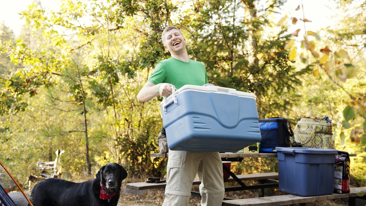 how to store food while camping: man with cool boxes