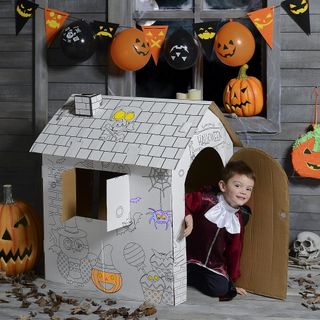 kids with haunted house wooden wall and balloons