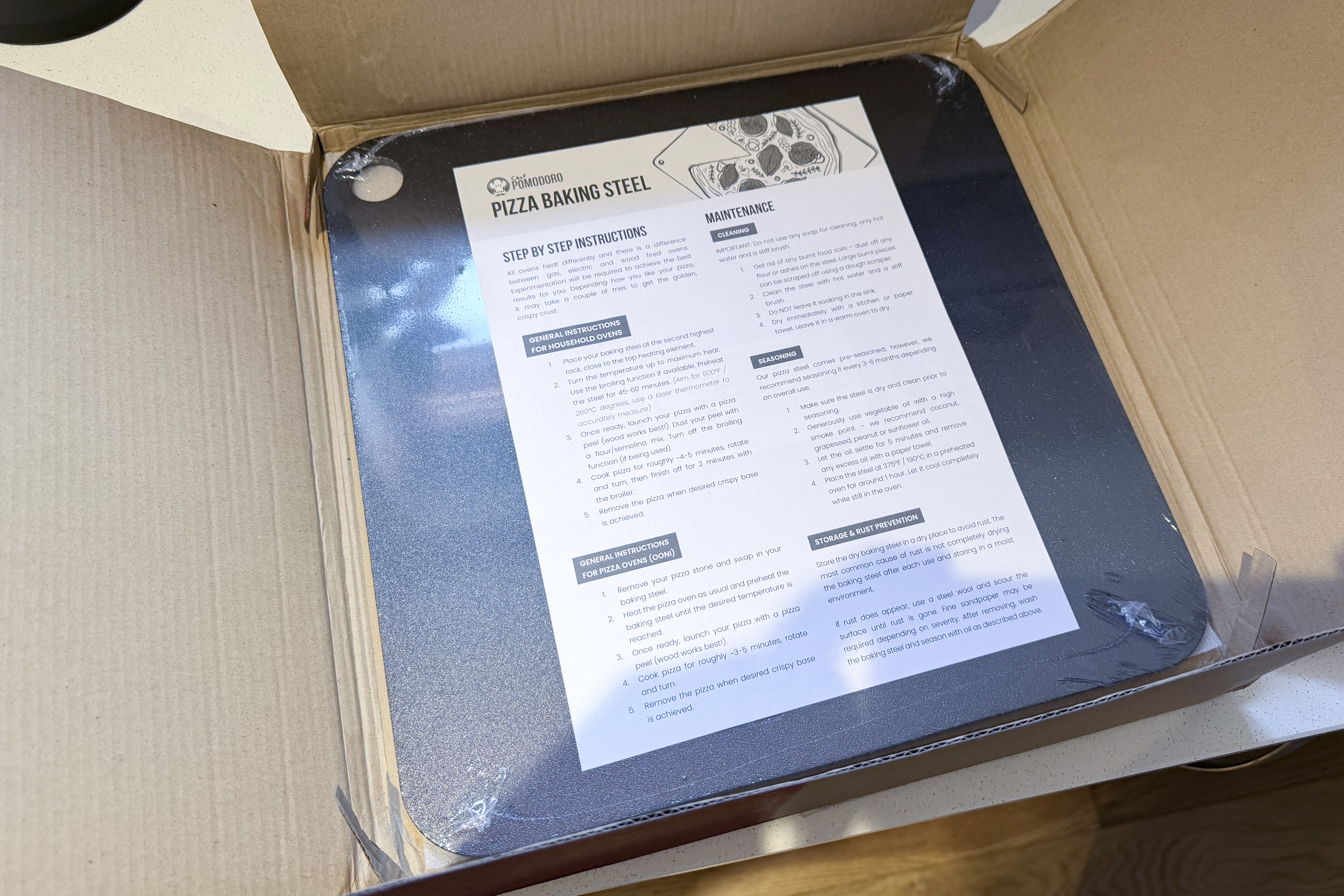 A pizza steel in its box on a counter