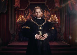 Mark Stanley as King Henry VIII, standing in the throne room holding a golden goblet