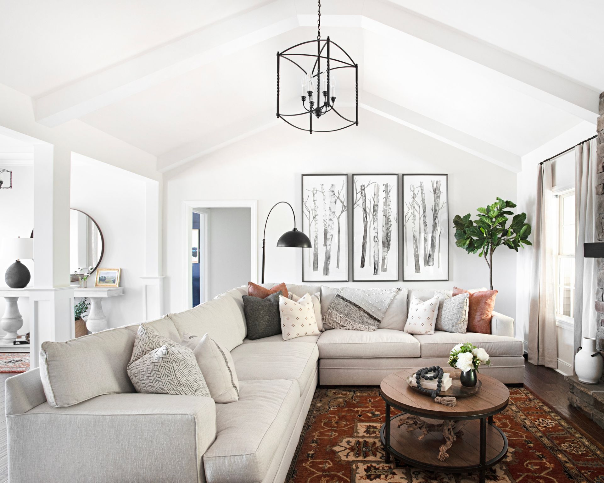 Είναι καλή ιδέα ένας λευκός καναπές; Λευκός καναπές σε σχήμα L σε λευκό τοίχο με αφηρημένη τέχνη