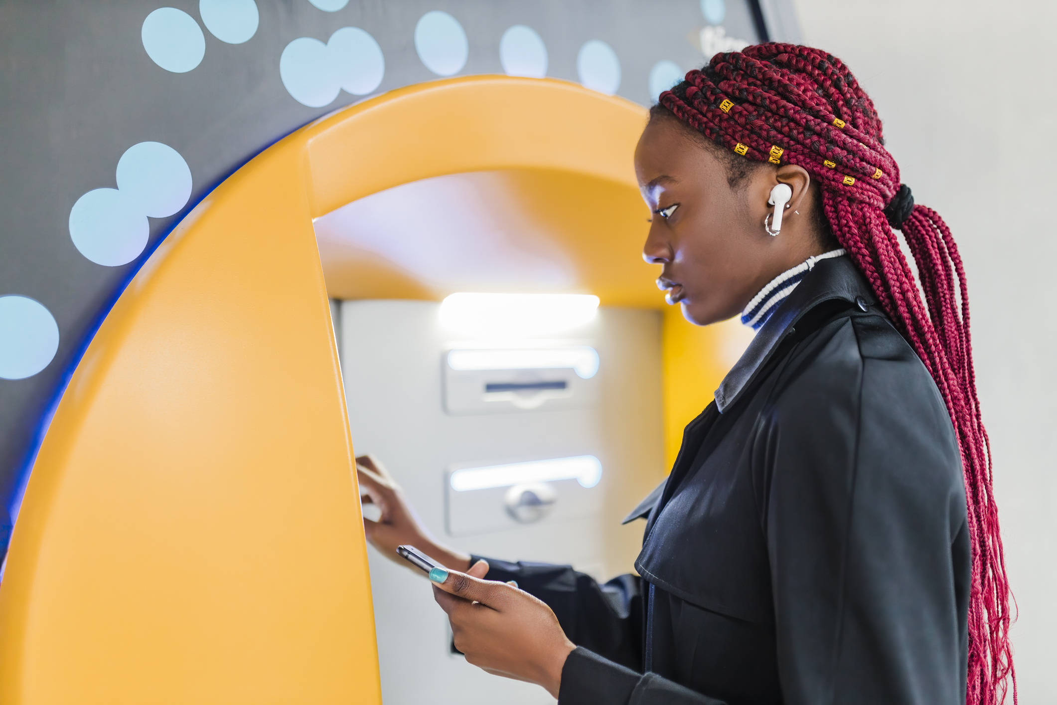 Young woman using ATM machine