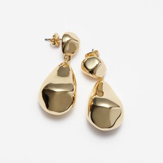 Gold Sculpted Pebbles Drop Earrings on a grey surface