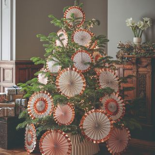 A Christmas tree decorated with oversized paper ornaments