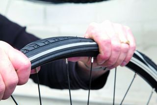 Image shows a person fixing a puncture