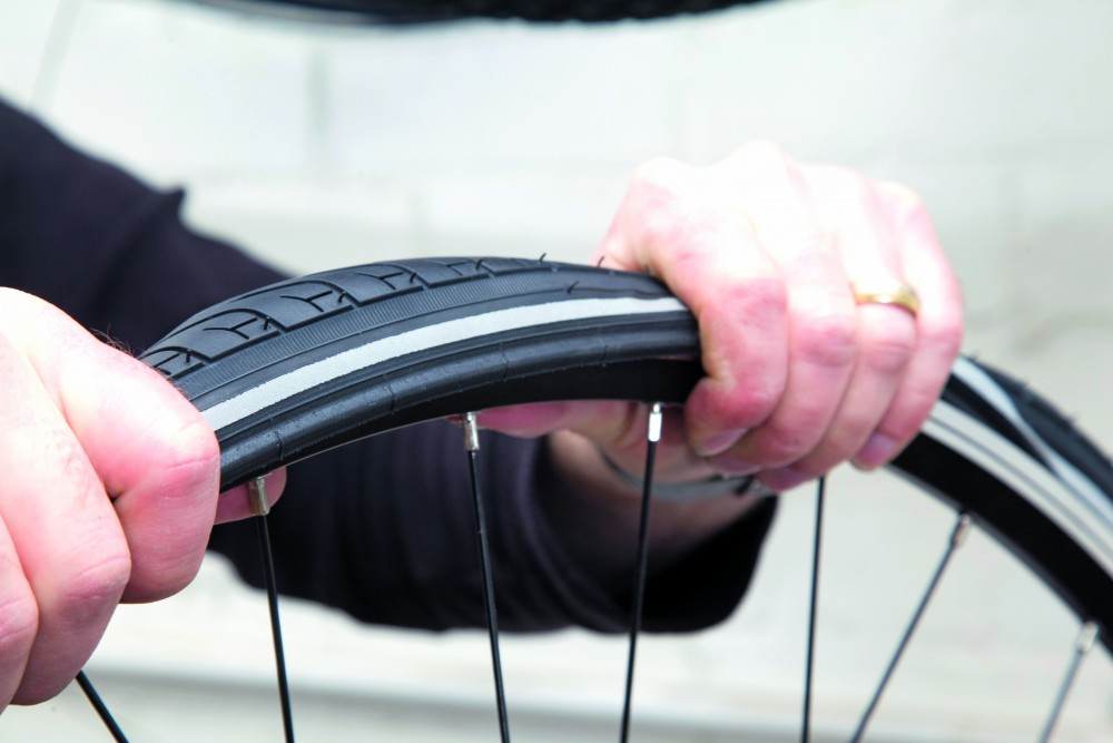 Image shows a person fixing a puncture