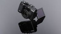Black Canon G1X camera with flip-out LCD screen, reflected on a glossy black surface