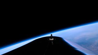 view of earth's atmosphere against the blackness of space from virgin galactic's vss unity space plane during its july 2021 spaceflight.