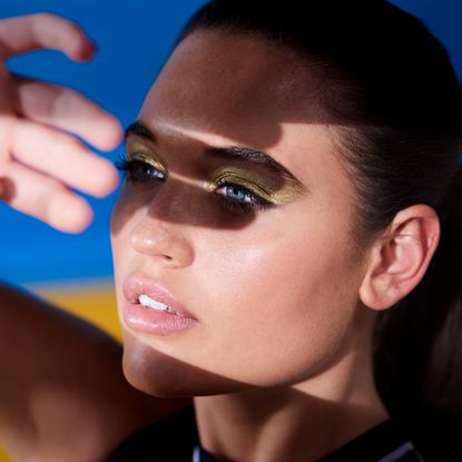 model blocking her face from the sun