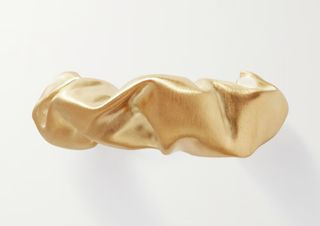 A gold hairclip by Completedworks