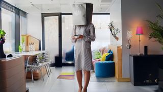 Woman hiding from camera with bag on head