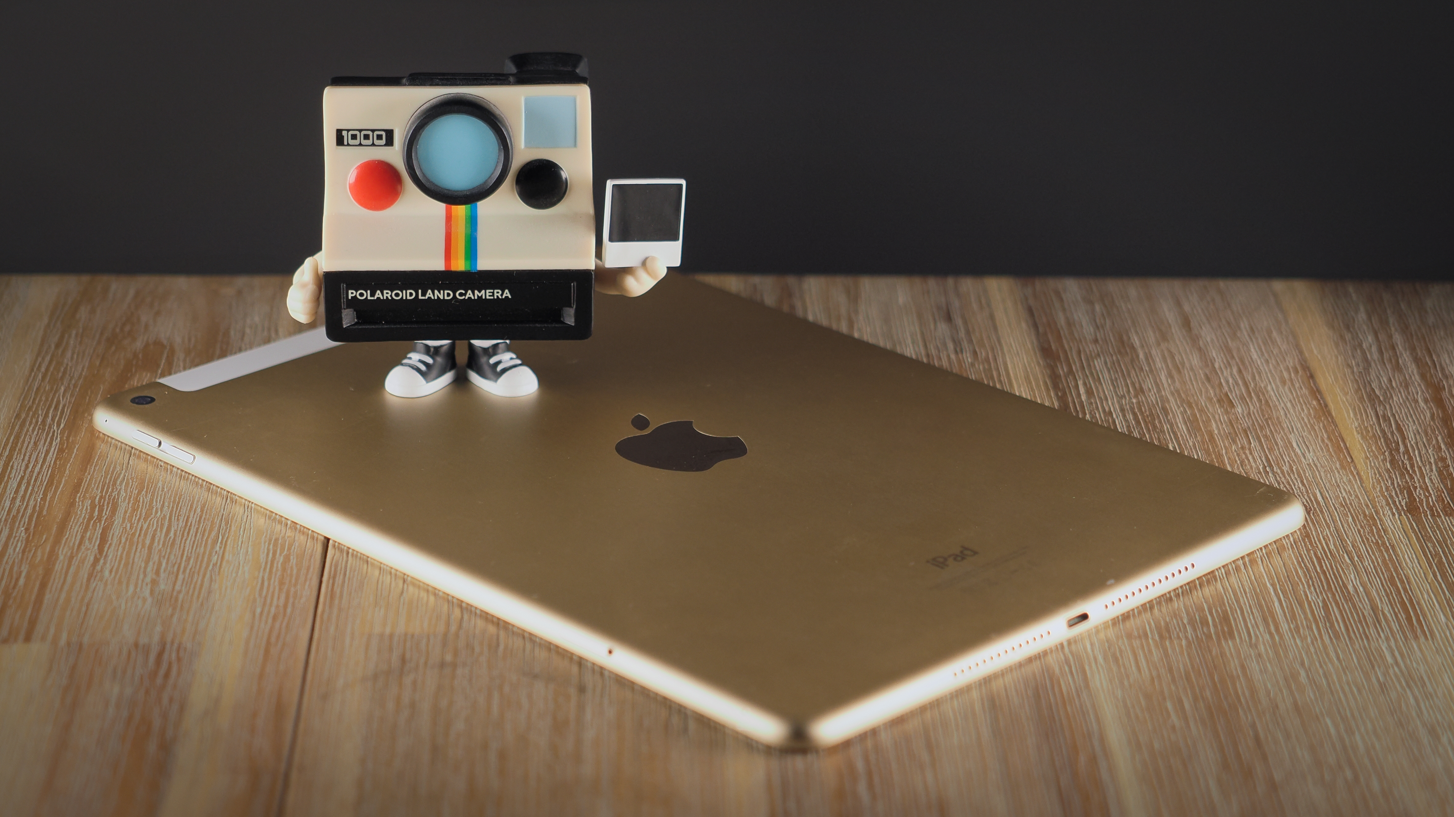 A Polaroid Funki Pop! standing on top of an iPad Air 2 on a wooden surface