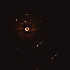 The two giant planets in the TYC 8998-760-1 system are visible as two bright dots in the center (TYC 8998-760-1b) and bottom right (TYC 8998-760-1c) of the frame, noted by arrows. Other bright dots, which are background stars, are visible in the image as well. By taking different images at different times, the team was able to distinguish the planets from the background stars. The image was captured by blocking the light from the young, sunlike star (top-left of center) using a coronagraph, which allows for the fainter planets to be detected. The bright and dark seen on the star&rsquo;s image are optical artifacts.