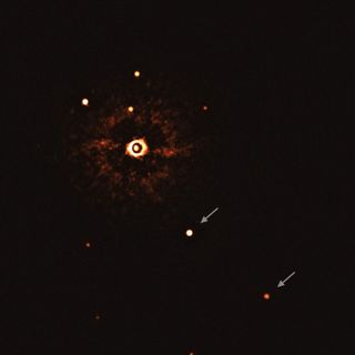 The two giant planets in the TYC 8998-760-1 system are visible as two bright dots in the center (TYC 8998-760-1b) and bottom right (TYC 8998-760-1c) of the frame, noted by arrows. Other bright dots, which are background stars, are visible in the image as well. By taking different images at different times, the team was able to distinguish the planets from the background stars. The image was captured by blocking the light from the young, sunlike star (top-left of center) using a coronagraph, which allows for the fainter planets to be detected. The bright and dark seen on the star’s image are optical artifacts.