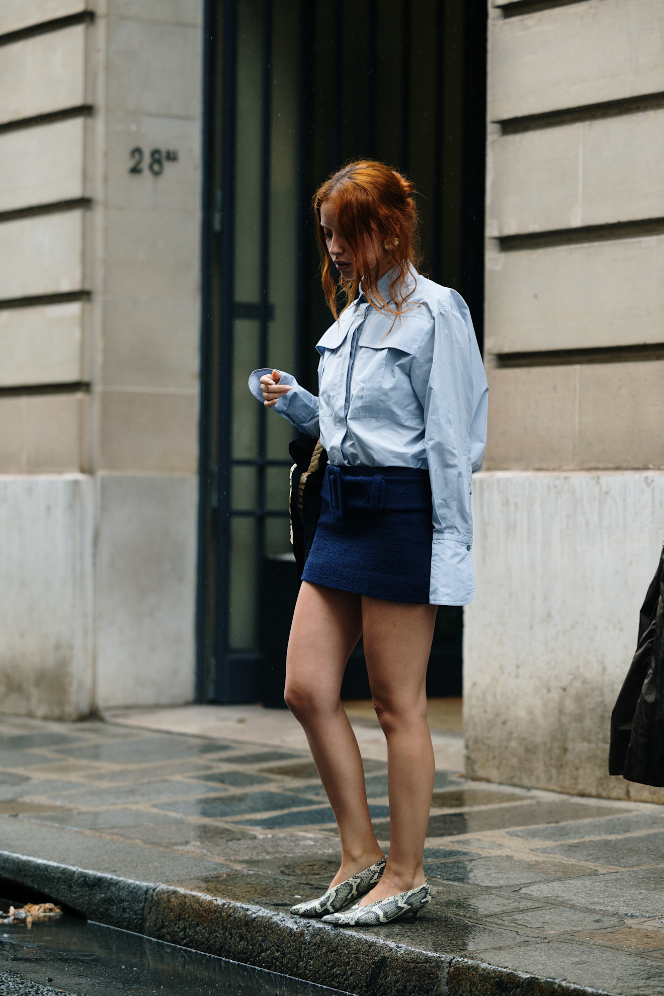 fashion week attendee wearing light blue jacket, navy skirt, snakeskin heels