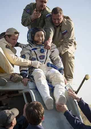 Japanese astronaut Koichi Wakata, commander of the International Space Station's Expedition 39 mission, is helped out of the Soyuz capsule after a successful landing of the Soyuz TMA-11M spacecraft near the town of Zhezkazgan, Kazakhstan on Wednesday, May