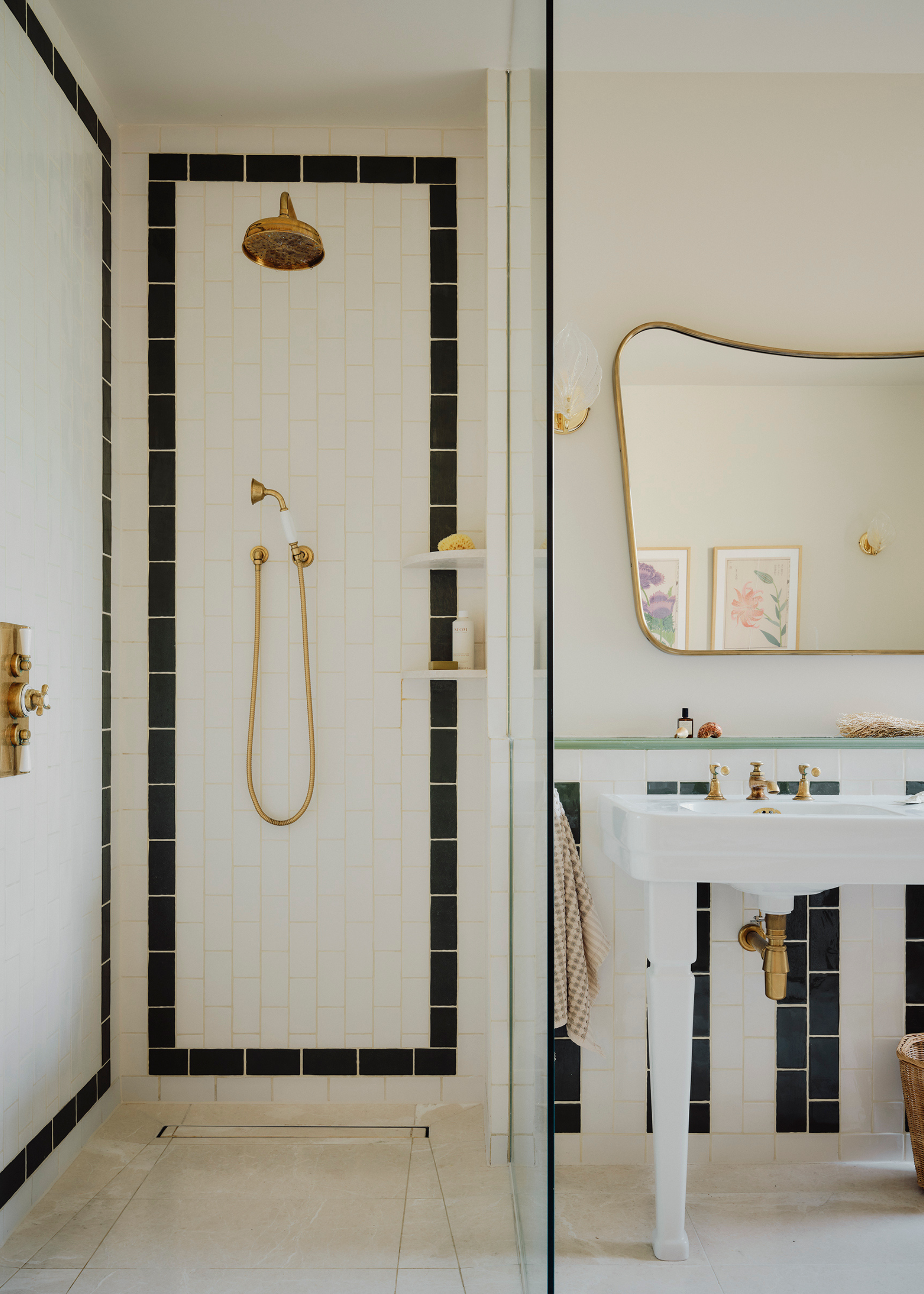 an open shower with black and white tiling and striped tiling off to the side