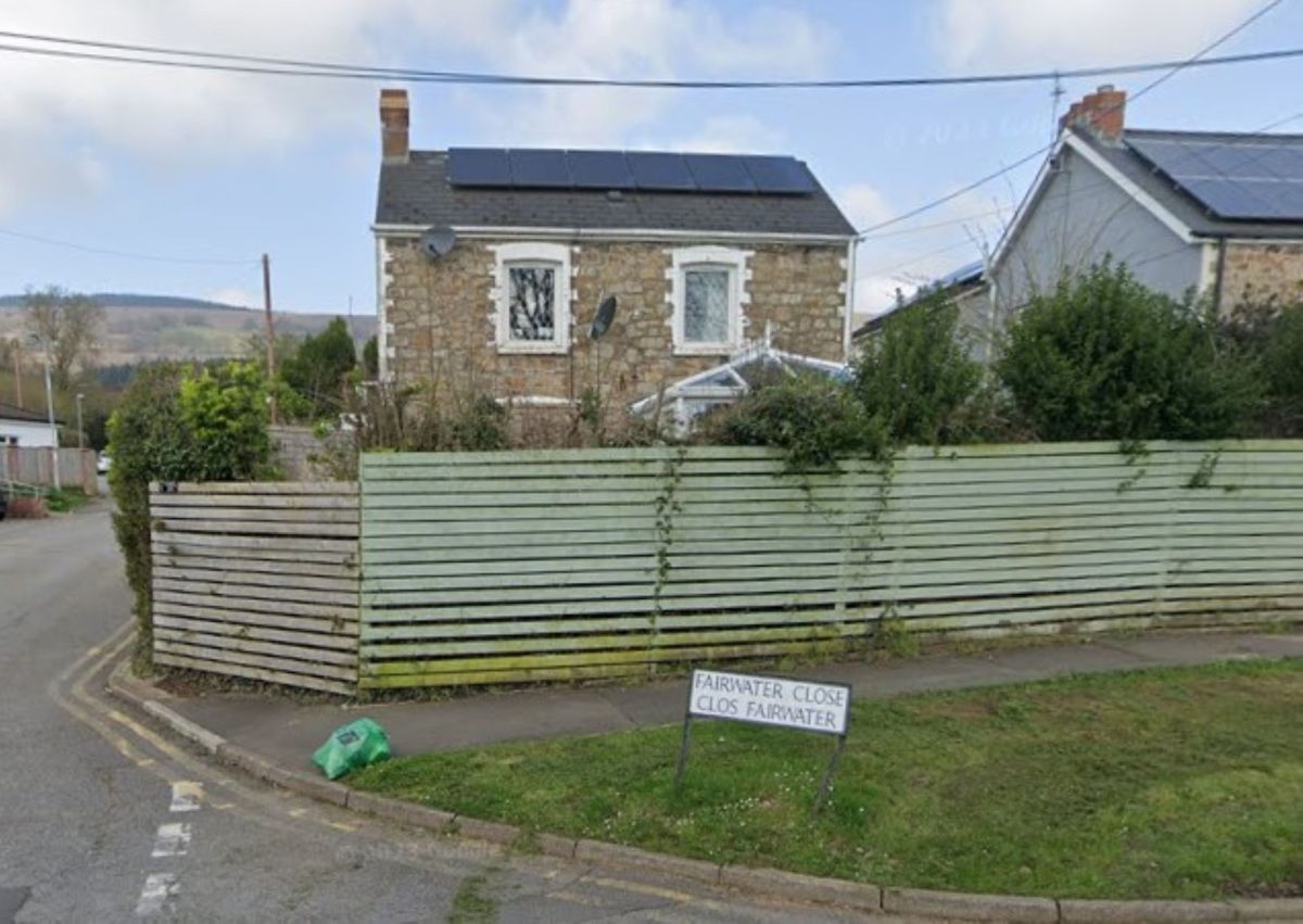 A conservatory visible from the road and over a garden fence