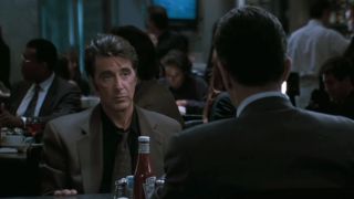 Al Pacino sitting in a diner booth across from Robert De Niro in Heat.