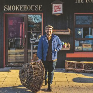 Banjo Beale by wicker basket in front of a seafood smokehouse