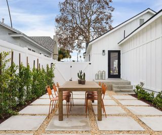 small patio to side of house with large pavers and gravel detail