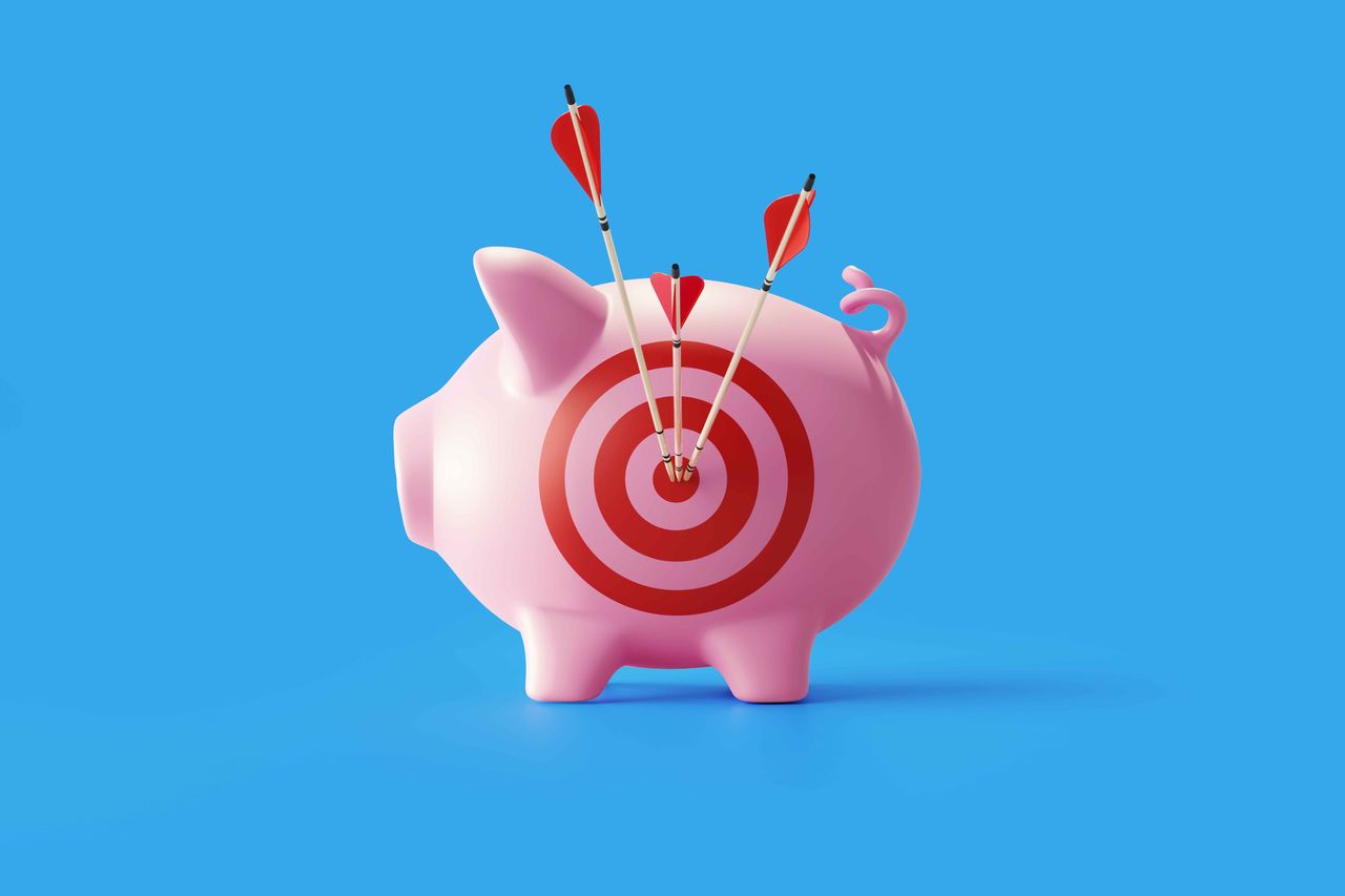 photo of a piggy bank with a target on its side and arrows 