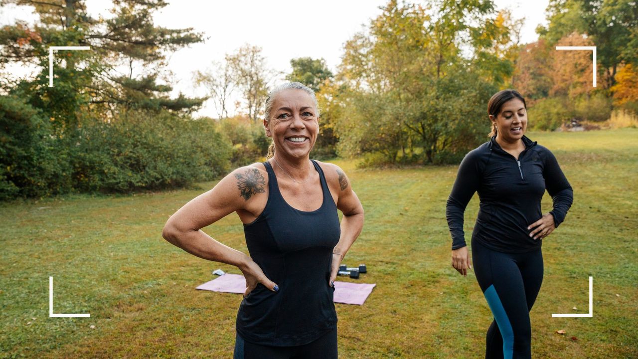 Two women using ankle weights to workout in the park, laughing and smiling together