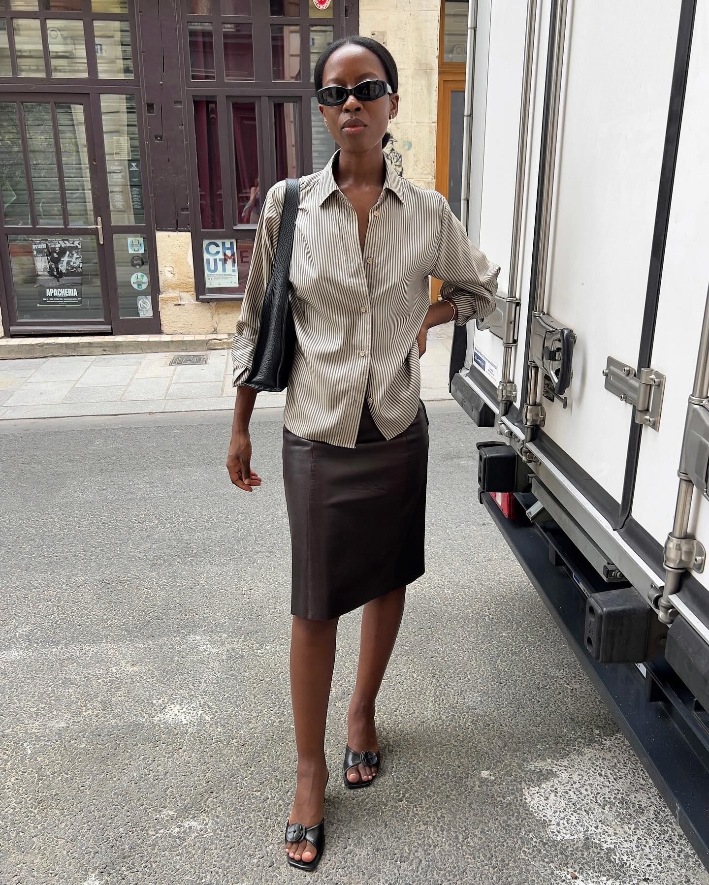 sylvie mus wears a striped shirt, pencil skirt and mules