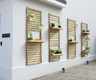 Wooden slatted wall mounts for attaching to garden walls as plant shelves