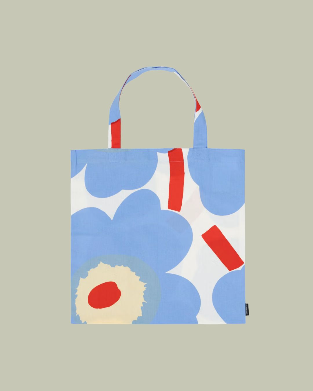 A tote bag with baby blye, red, and white floral designs, against a pale green background.