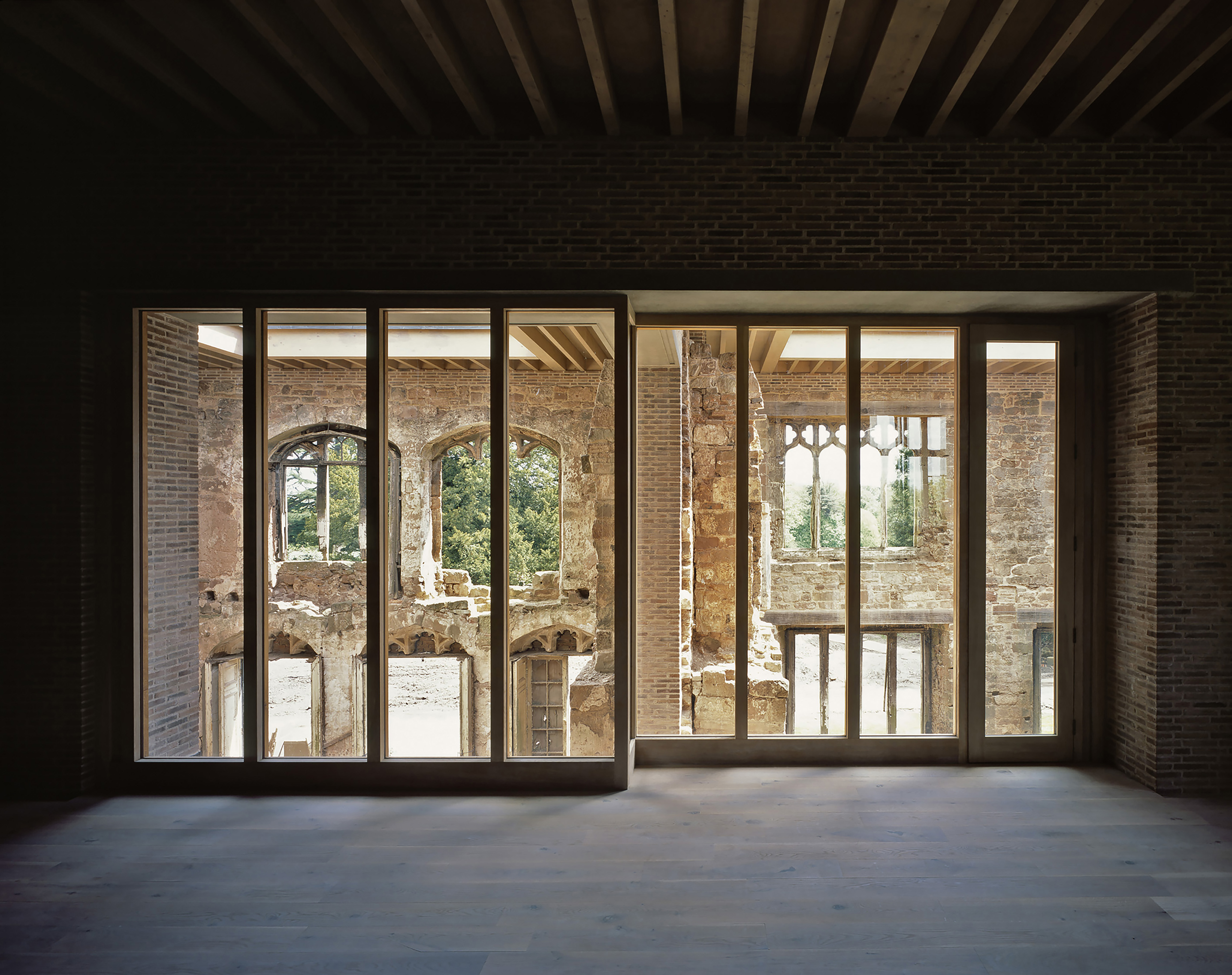 Full-height window allowing view through to a medieval courtyard in Astley Castle