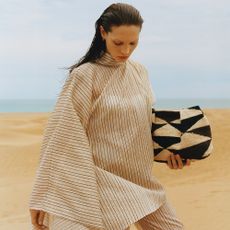 lady holding a black and white bag on beach