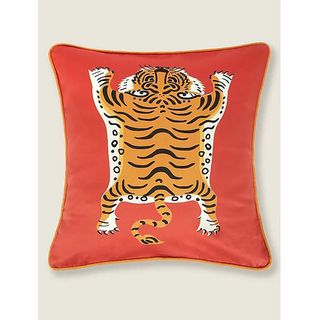 Red cushion with tiger on front.