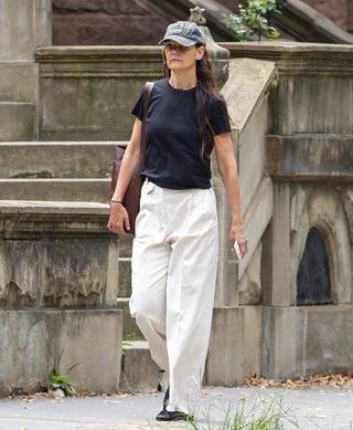 katie holmes walks in New York City wearing a black t shirt and khaki pants