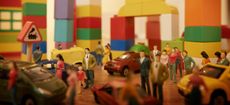 Toy cars and figurines in pretend plastic block town