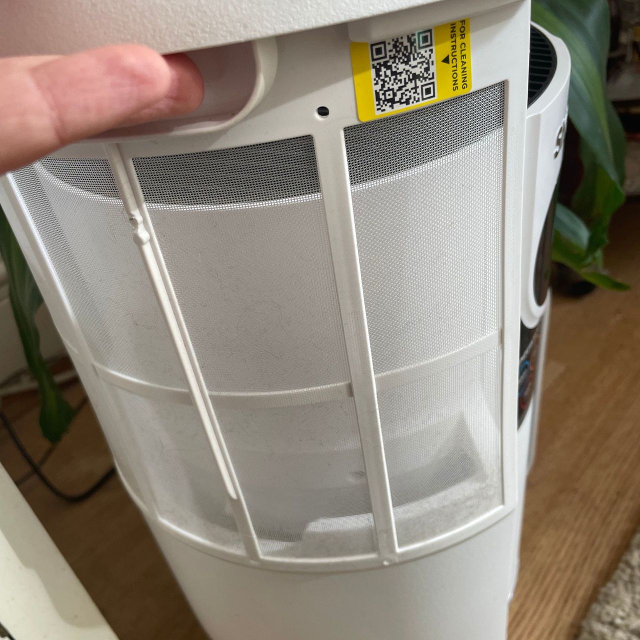 Hand pulling up the dust mesh filter of the Shark NeverChange 5 Air Purifier