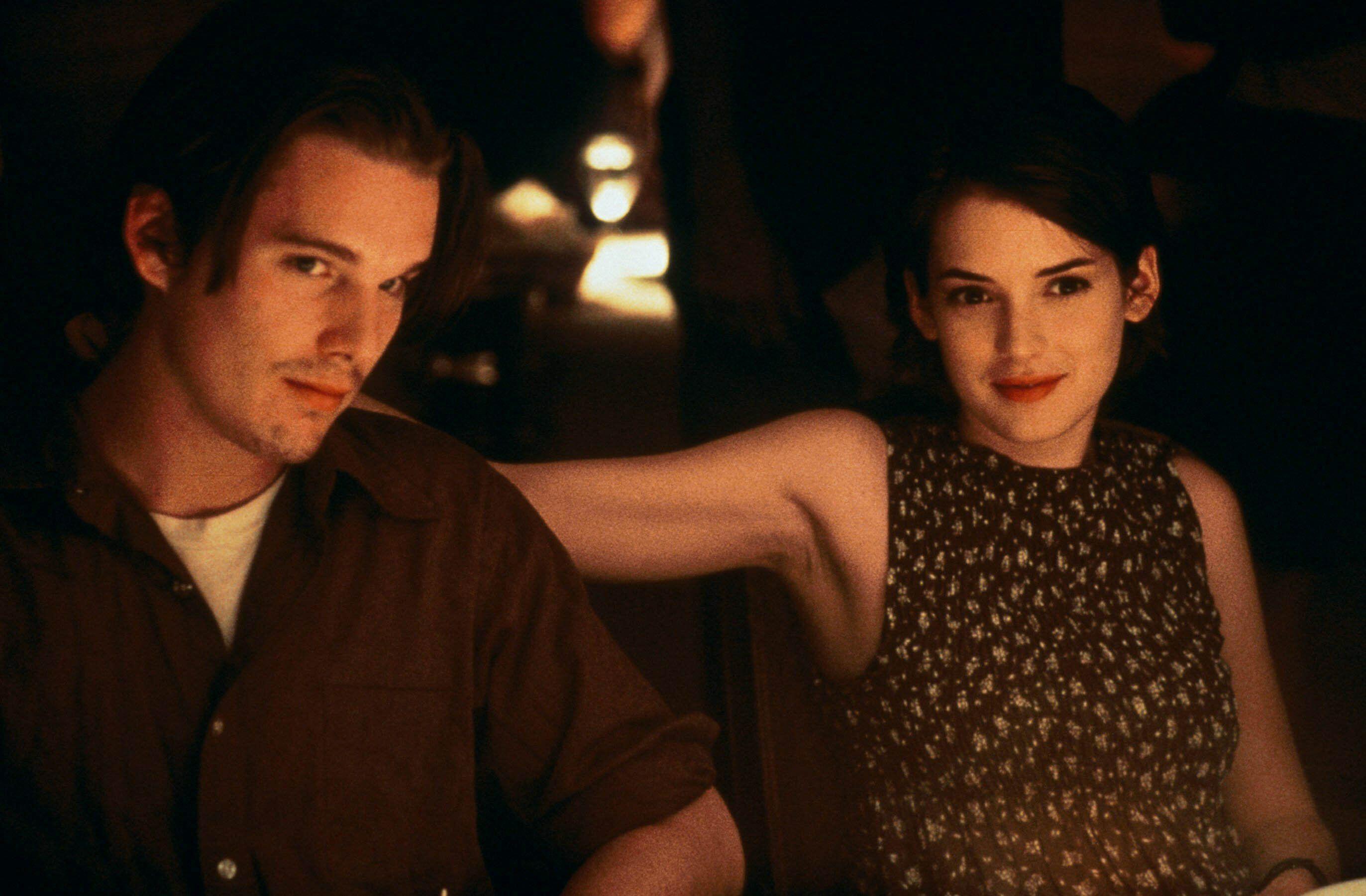 ethan hawke and winoa ryder sit in a booth together in a still from reality bites