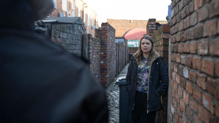 Tracy in the ginnel looking worried as Rob looms with his hood up