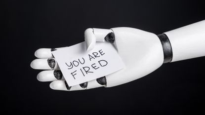 Robot arm holding &ldquo;you are fired&rdquo; slip