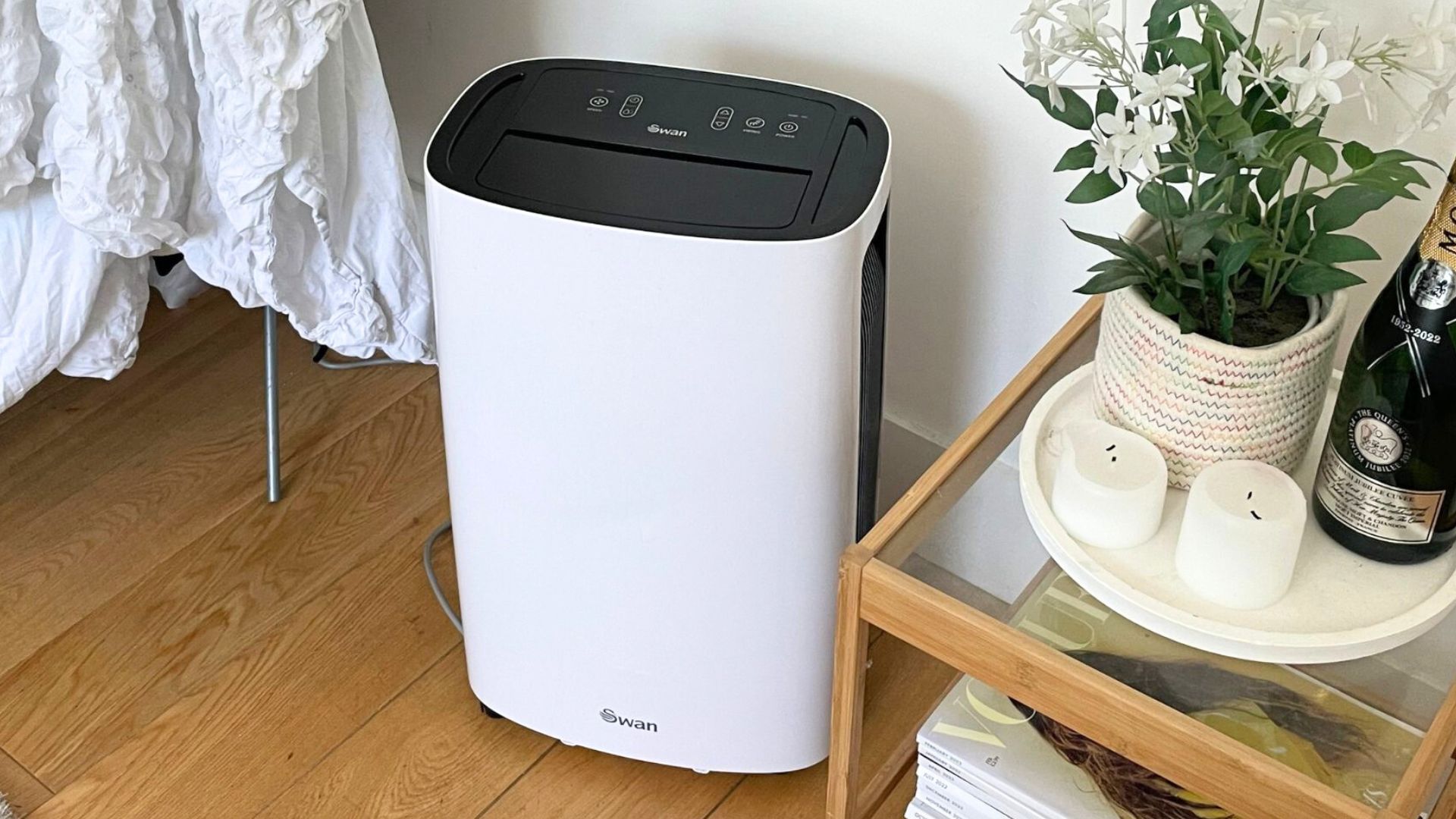 picture of a dehumidifier in a front room with launry and candles next to it