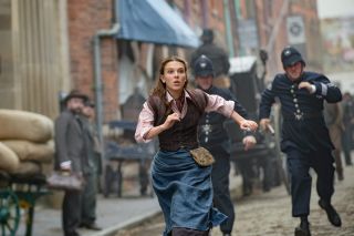 Millie Bobby Brown running from police officers in Enola Holmes 2