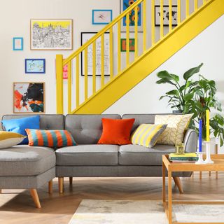 grey L shaped sofa in living room with yellow staircase