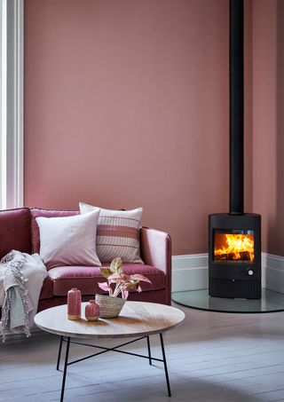 A living room with pink wall paint decor and modern fireplace