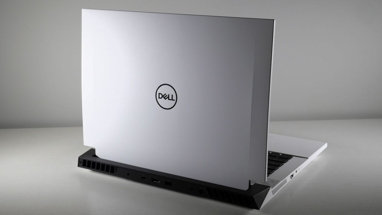 Dell G16 (7630) open on a white table with its lid facing the camera. The lid is white, angled like a car hood, and features a Dell logo at the center.