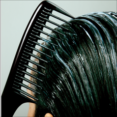 combing white product through black hair