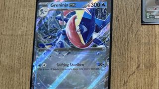 A Greninja ex card on a wooden table