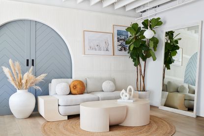 A living room with white furniture and blue arched panelled doorway