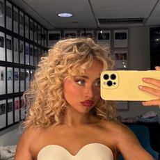 Sabrina Carpenter wearing a sculptural corset and posing with a Chloe Paddington