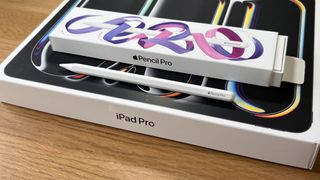 A white Apple Pencil Pro being used with an iPad Pro M4